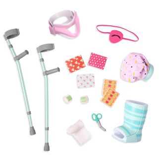 Image of a set of doll accessories for 18 inch dolls with crutches, eye patch, neck brace, ice pack, walking foot cast, gauze roll, scissors, and assorted bandages. Links to Target website.