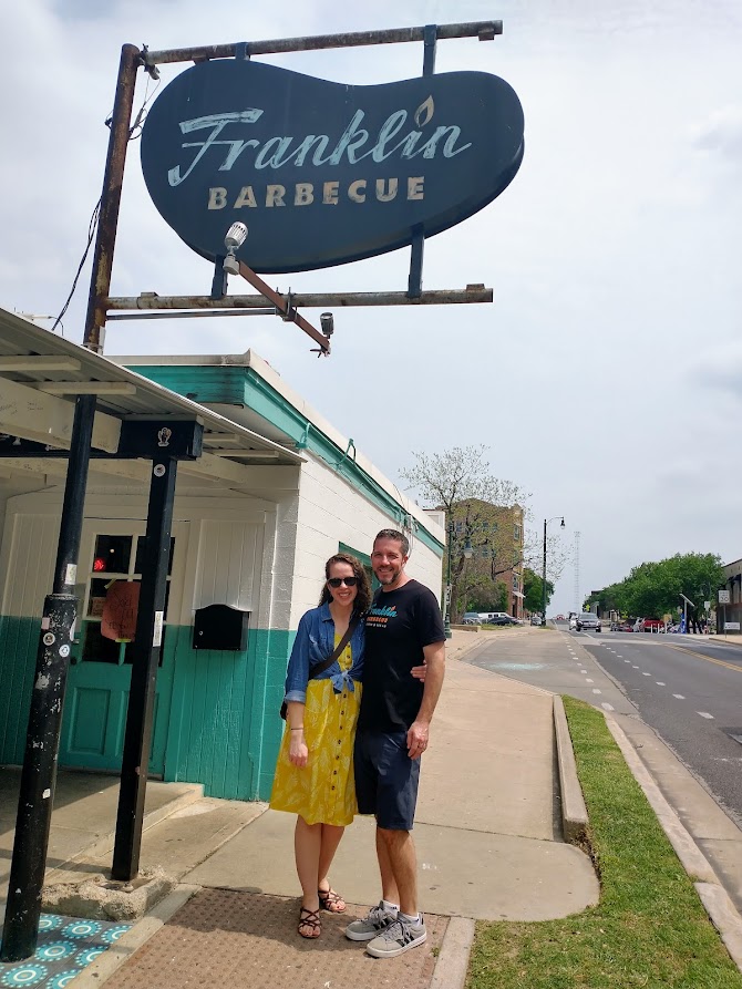 Image of the author and her husband under the Franklin Barbecue sign, by Livable by Design